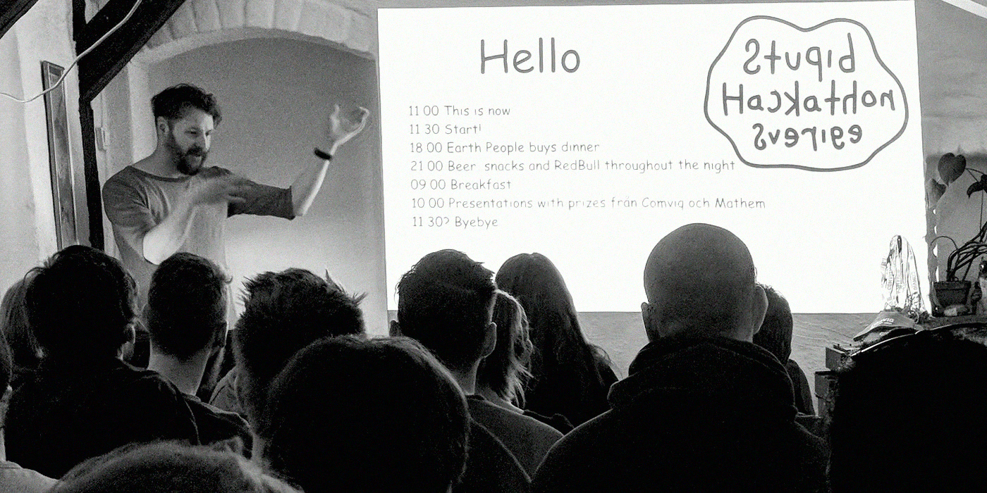 The host welcoming a packed room in front of the “Hello” slide.