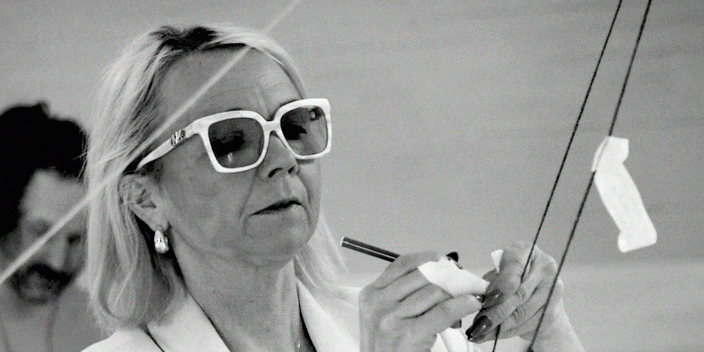 A participant in white glasses writing a note among the yarn.