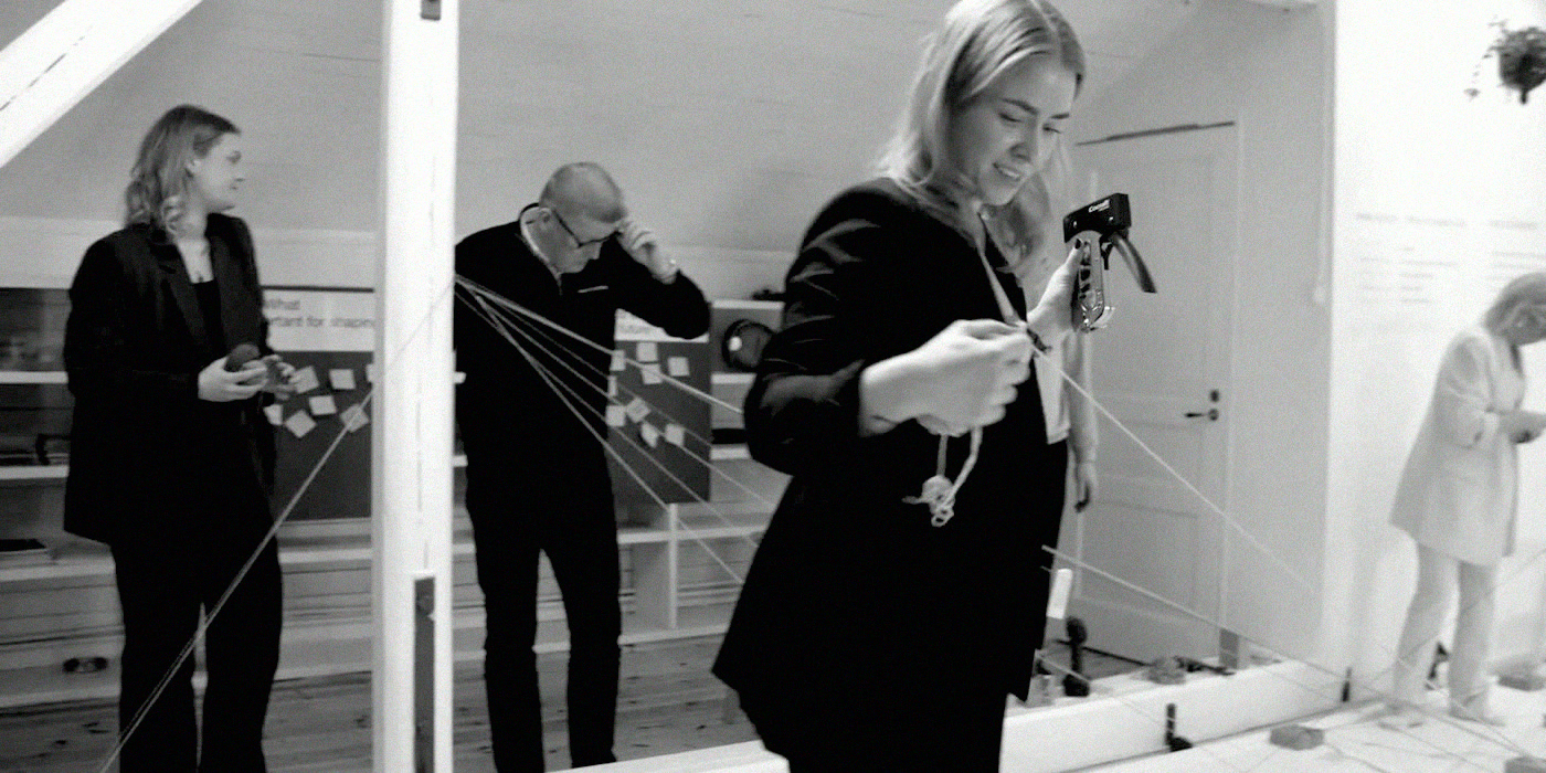 Participants threading yarn across the room between their notes.