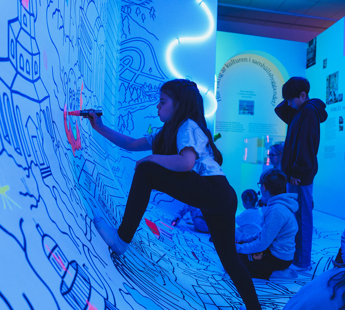 A visitor drawing on the wall of the Society Expo exhibition