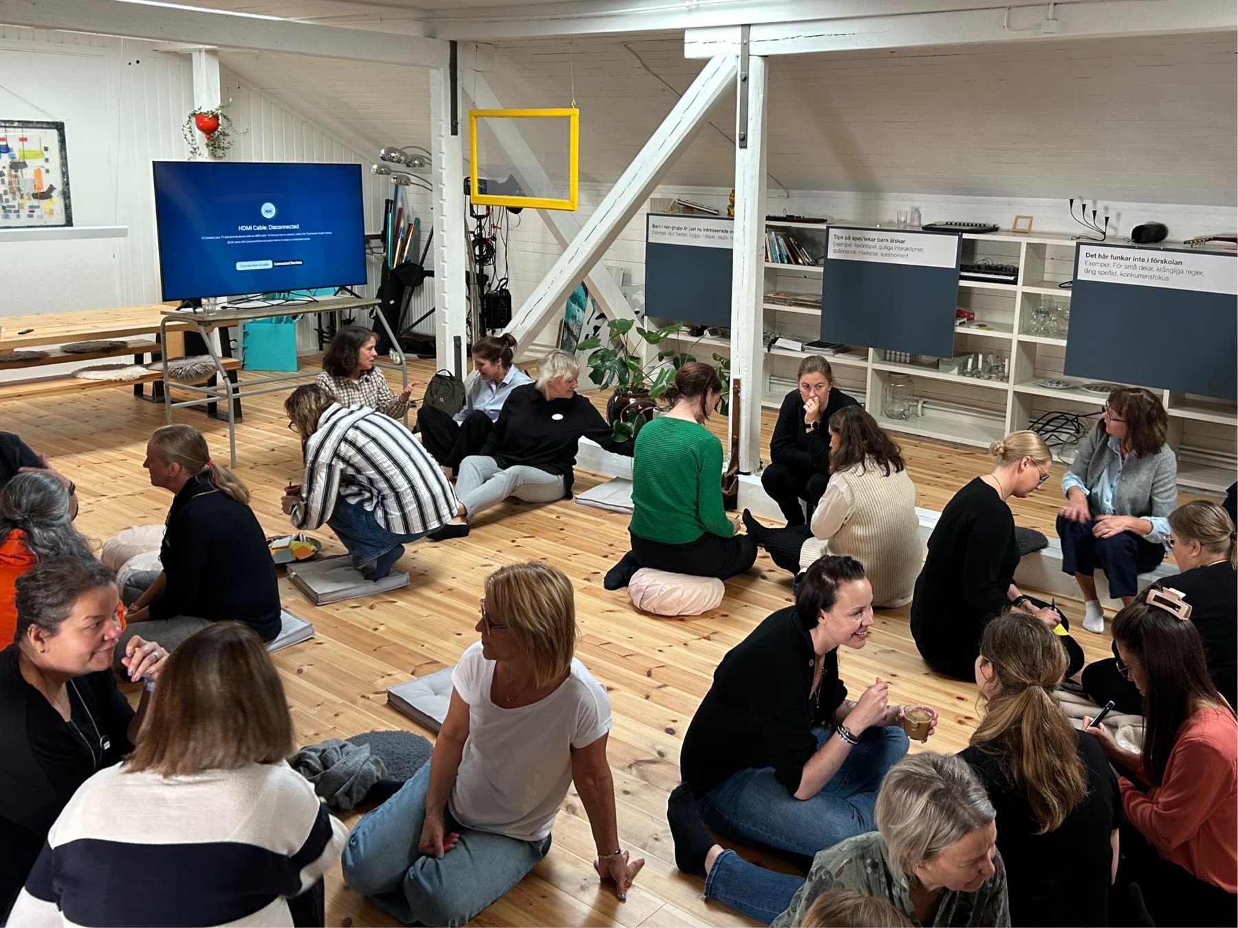 Preschool teachers sitting on the floor in a workshop