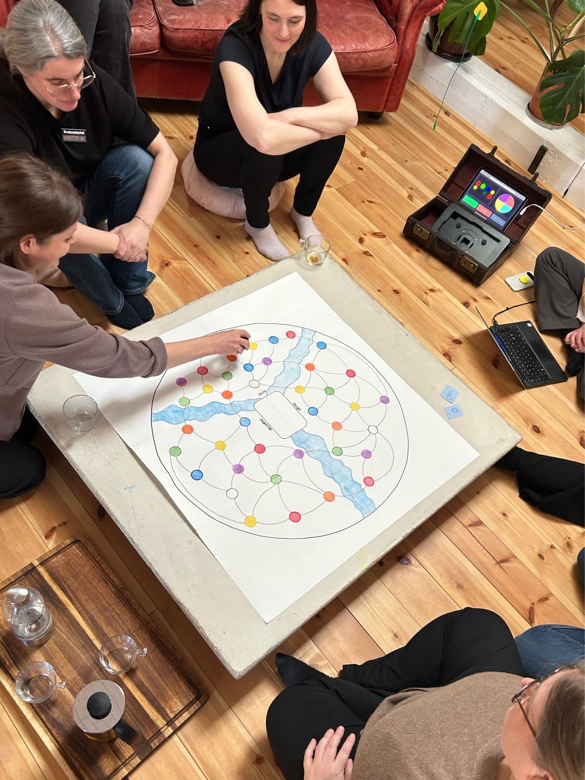 A hand-drawn game board being played on the floor