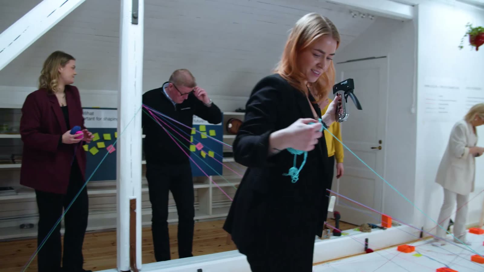 A participant tying yarn while others look on