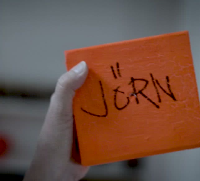 A hand holding an orange block with the word Jörn