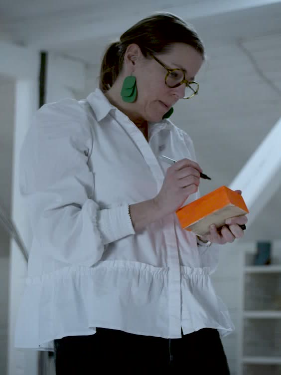 A participant writing on an orange block